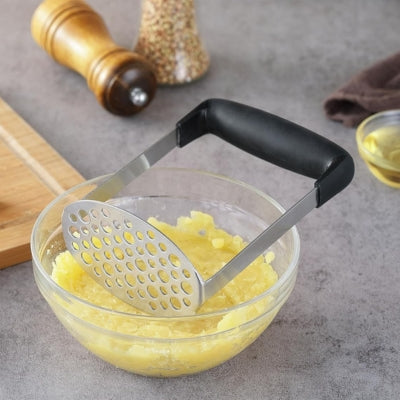 presse-puree-manuel-noir-dipose-sur-bol-puree